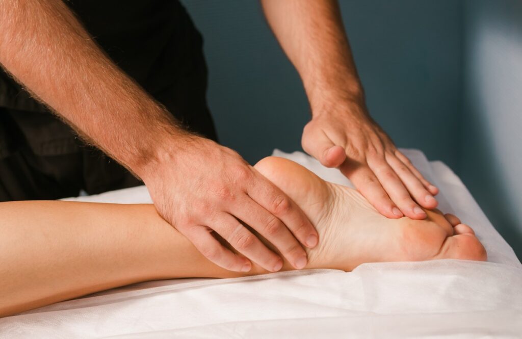 Mandlig massør giver kvinde wellness fodmassage